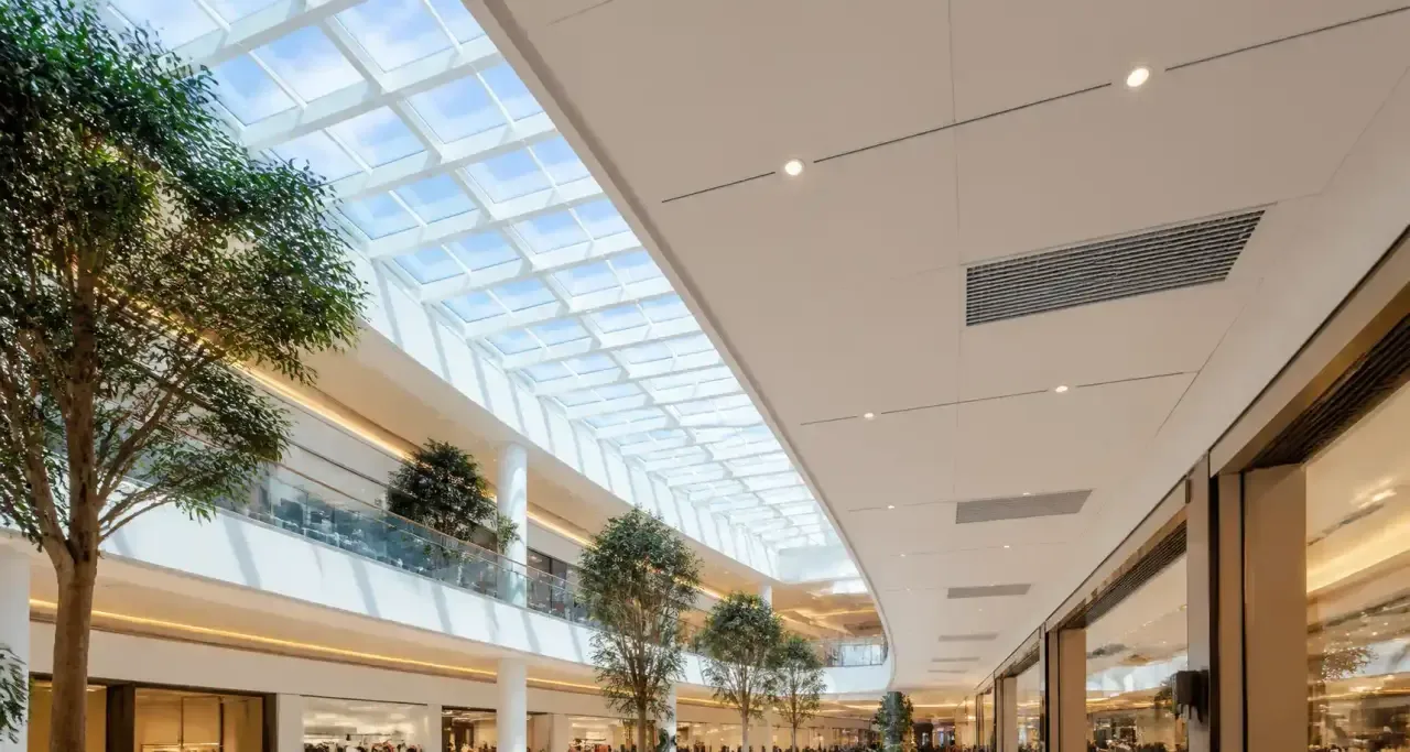 Grille de désenfumage encastrée au plafond d'une galerie de centre commercial
