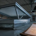 Exutoire de fumée en toiture, technicien vérifie le système de sécurité incendie